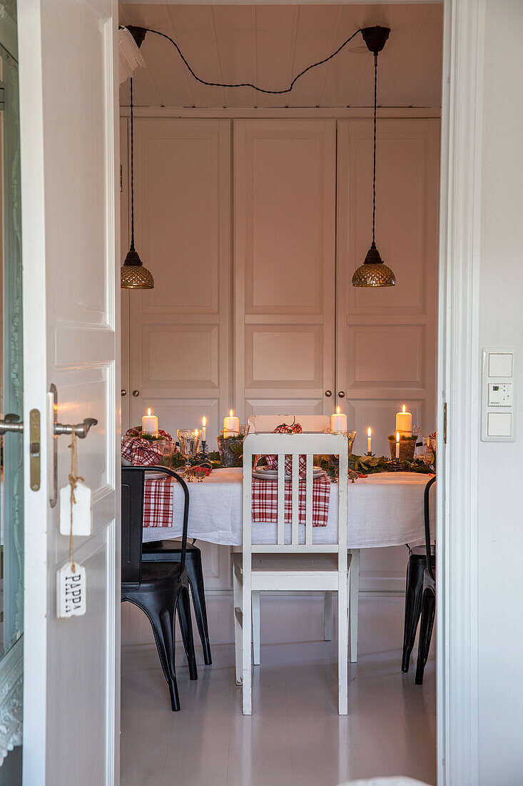 Festively decorated dining room with candles and pendant lights