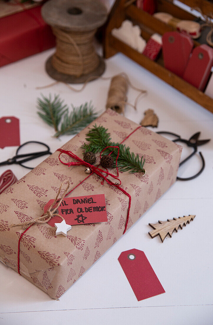 Weihnachtlich verpacktes Geschenk mit Tannenzweigen und Anhänger