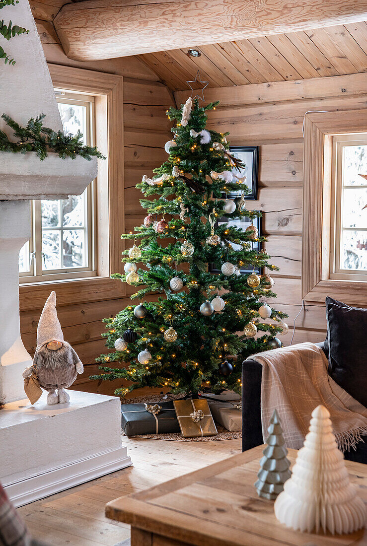 Rustikales Wohnambiente mit Weihnachtsbaum in einer Blockhütte
