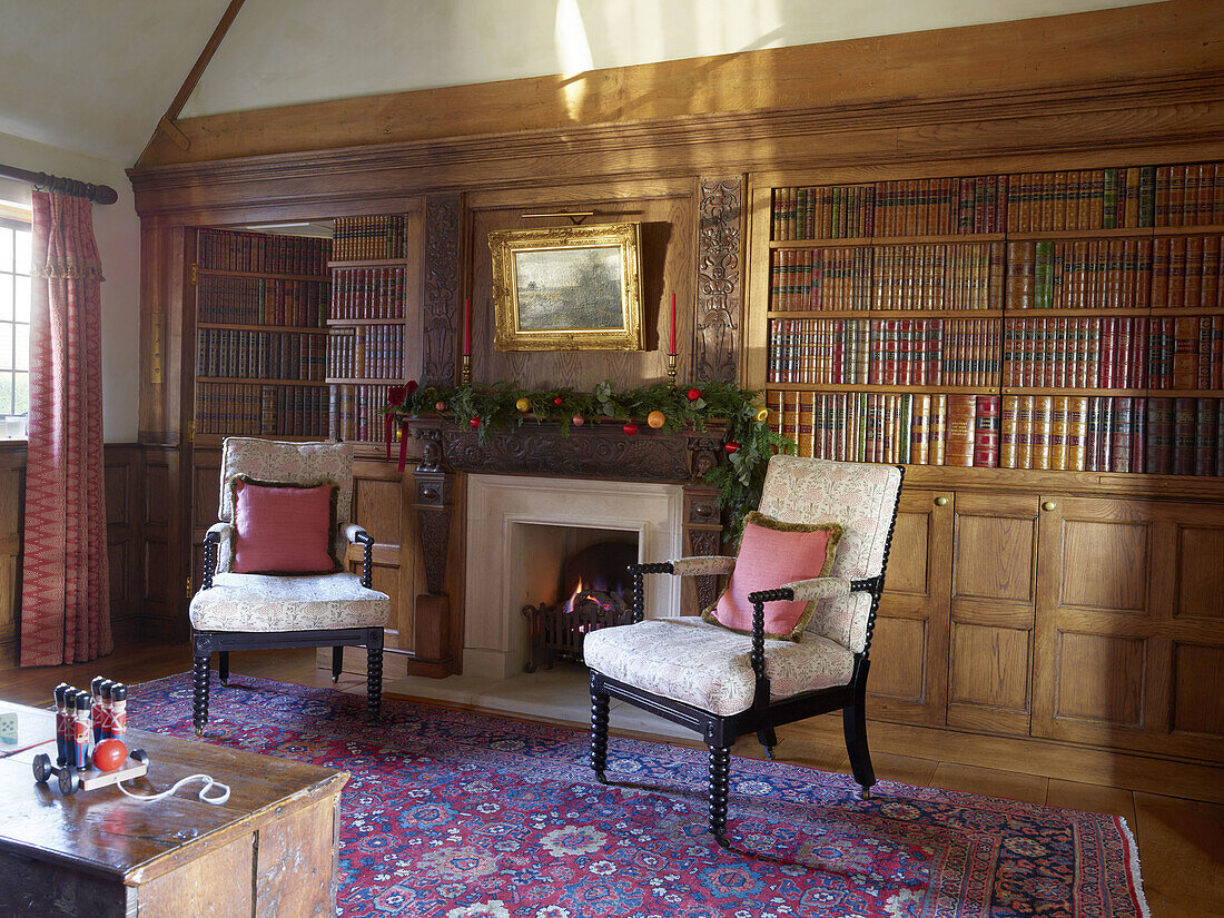Traditionelles Wohnzimmer mit Kamin, Holzvertäfelung und Bücherregalen