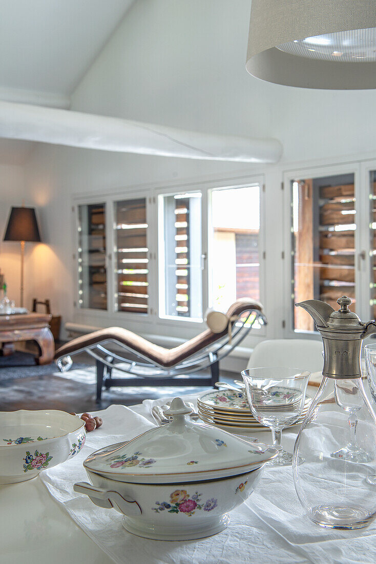 Set table with antique porcelain crockery and view of the living room