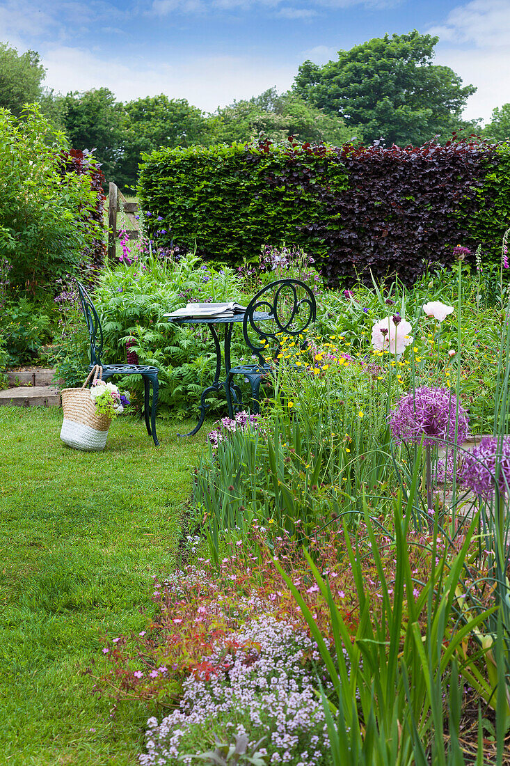 Seating area with metal furniture in flowering garden