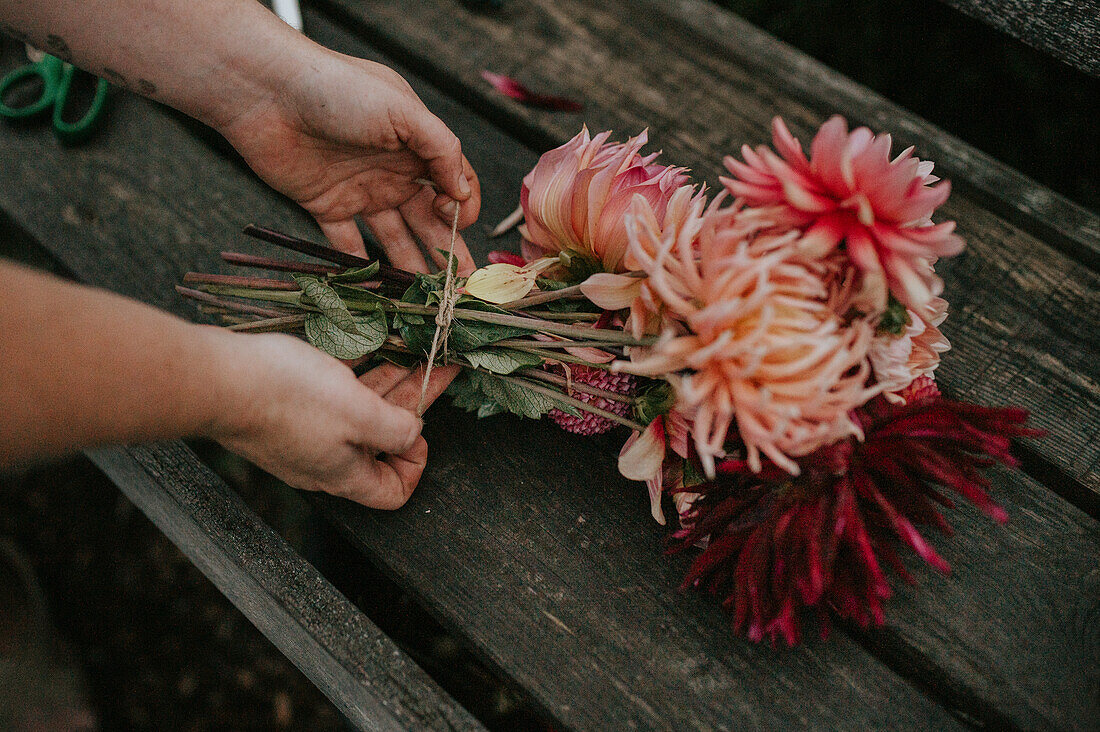 DIY flower bouquet with dahlias tied on a wooden table