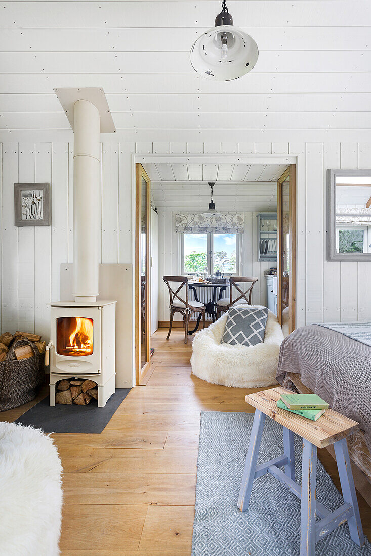 Open-plan living room with white wood-burning stove and country-style dining area