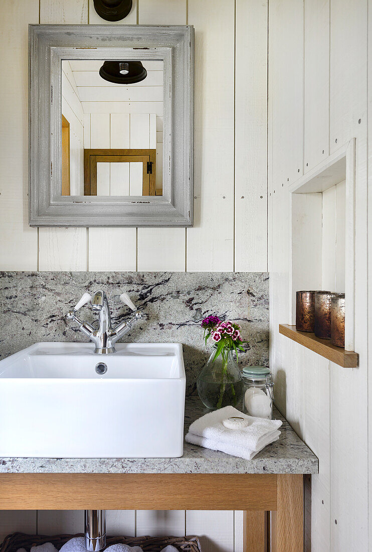 Washbasin with marble top, wooden paneling and mirror