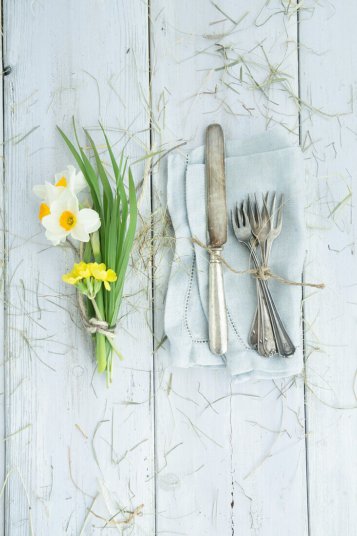 Bouquet of daffodils and cutlery on linen napkin