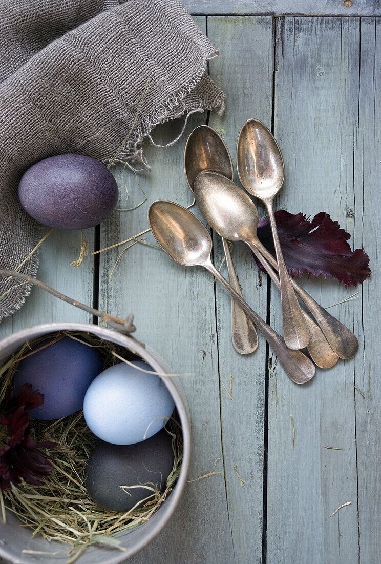 Arrangement with silver cutlery and Easter eggs, dyed with red cabbage and beetroot