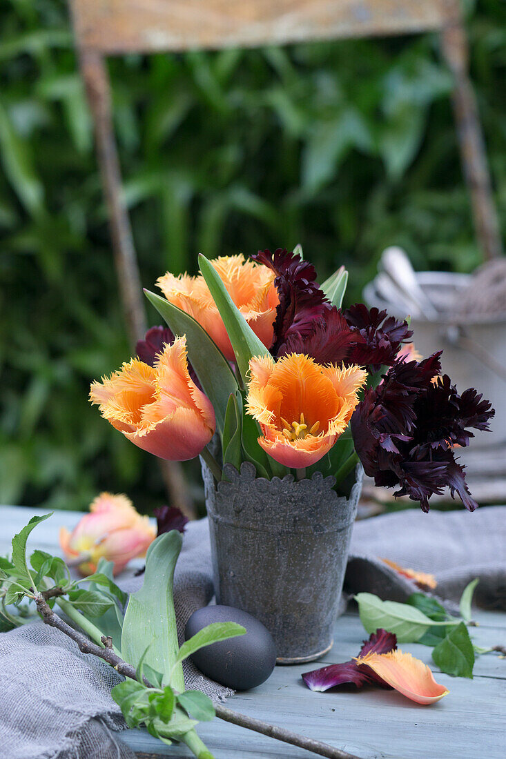 Gefranste Tulpen (Tulipa) im Blumenstrauß im Metallgefäß und Ostereier