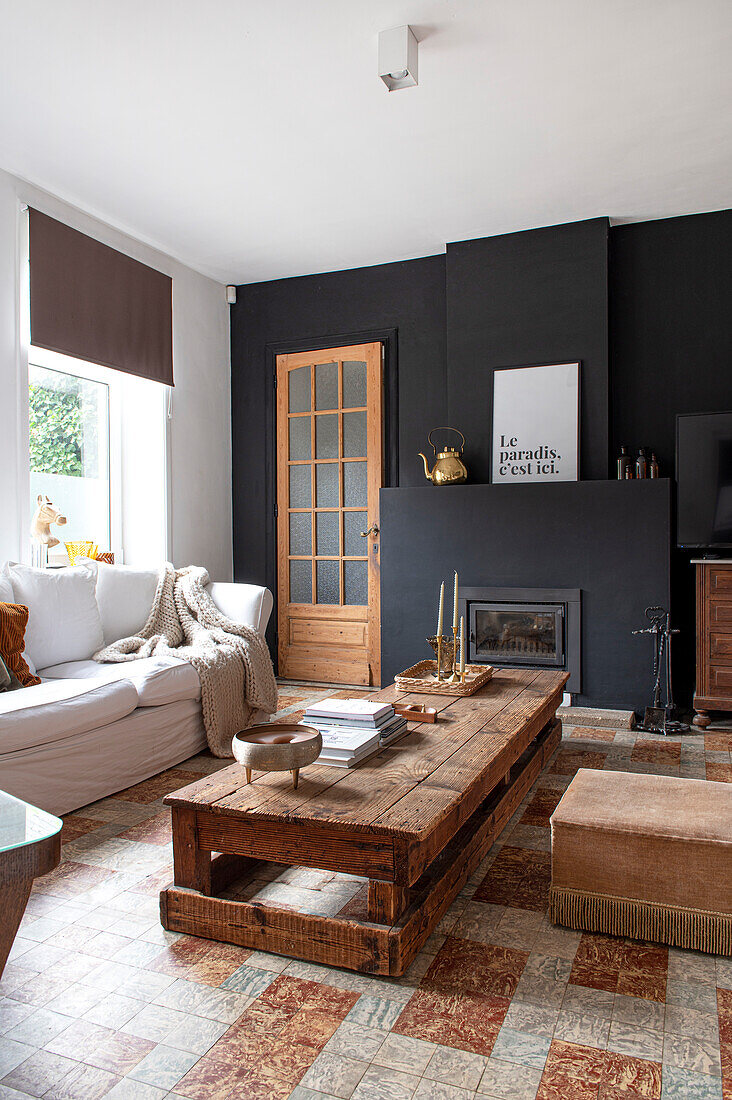 Living room with rustic wooden coffee table and fireplace with dark wall paneling