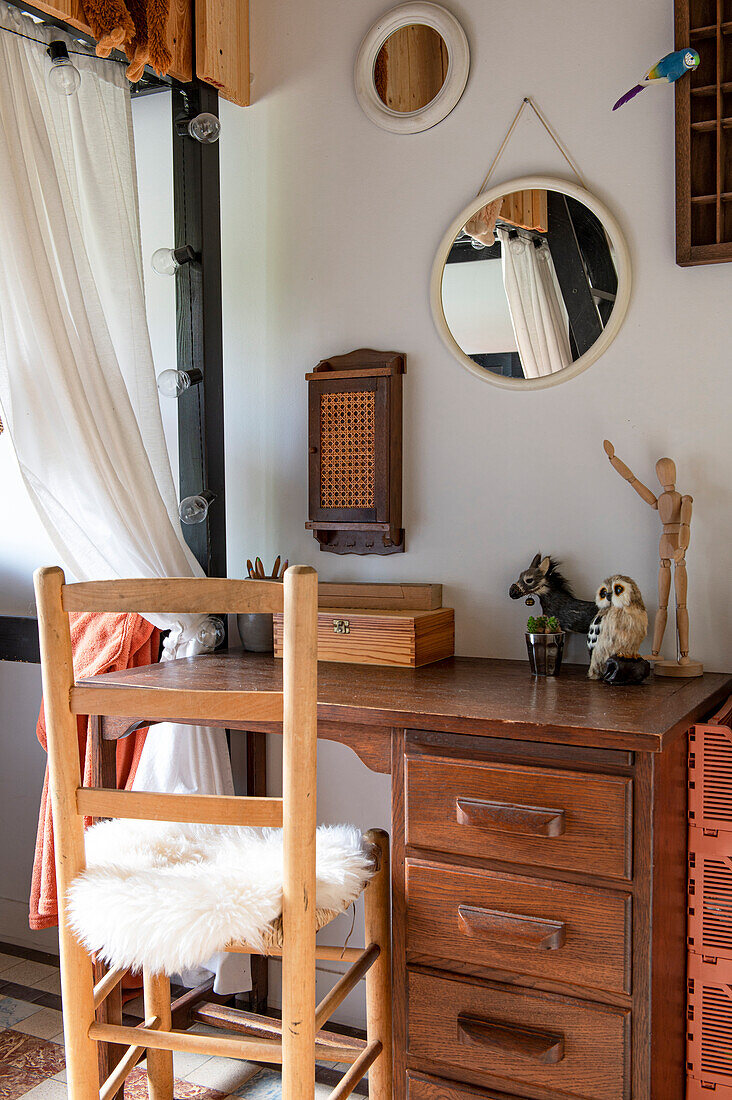 Desk with wooden chair, mirror and decorative objects