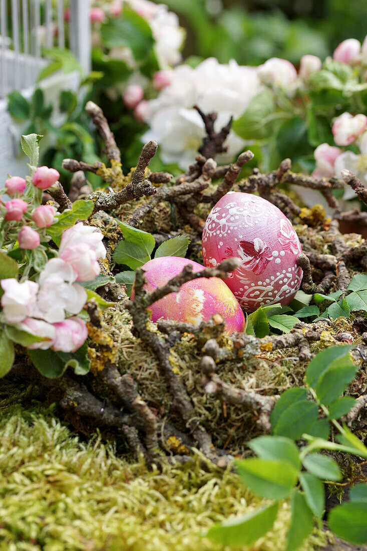 Selbst bemalte Ostereier im Nest aus Blütenzweigen