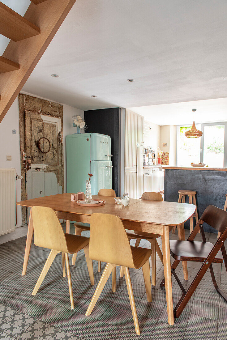 Holztisch mit hellen Stühlen in Küche mit Retro-Kühlschrank