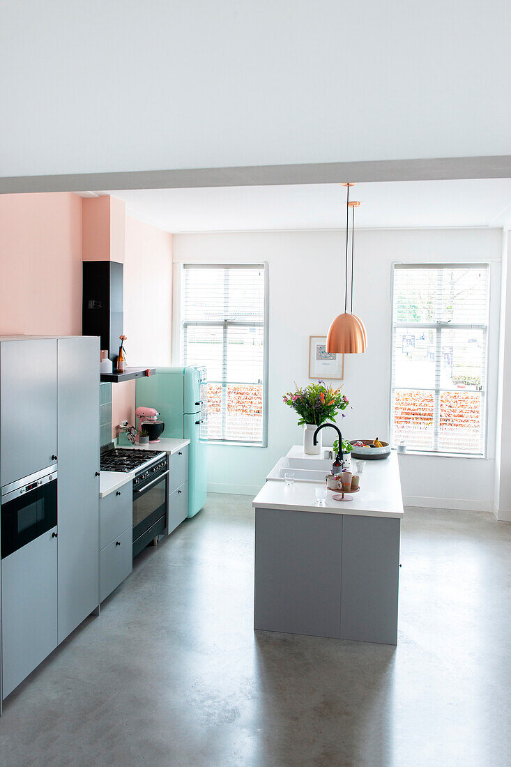Moderne Küche in Pastellfarben und zentraler Kochinsel