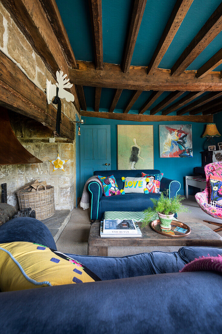 Wohnzimmer mit freiliegenden Holzbalken und farbenfroher Einrichtung