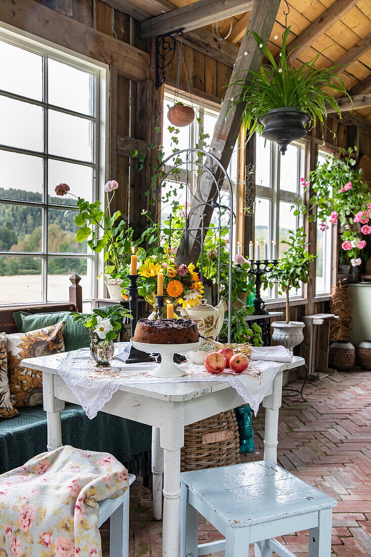 Gartenhaus im Landhausstil mit Pflanzen und gedecktem Tisch