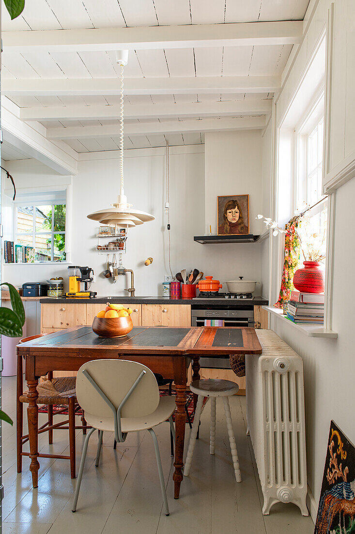 Country-style kitchen with white wooden ceiling and dining area