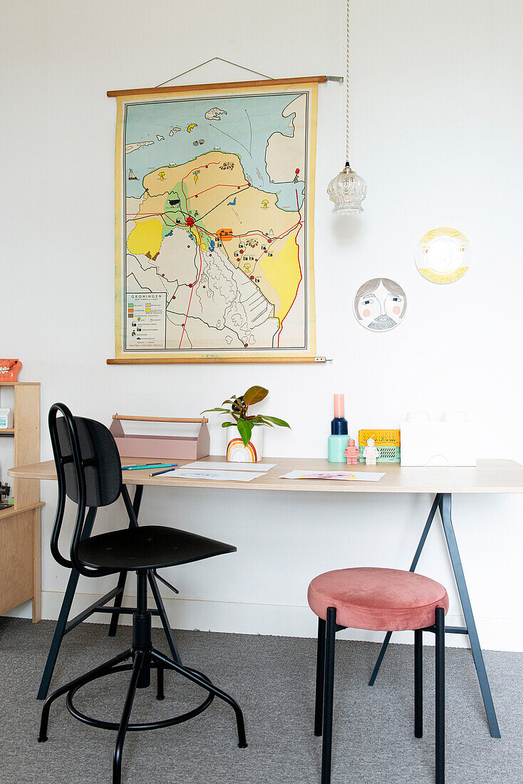 Arbeitsplatz mit Wandkarte, modernem Schreibtisch und Designstühlen