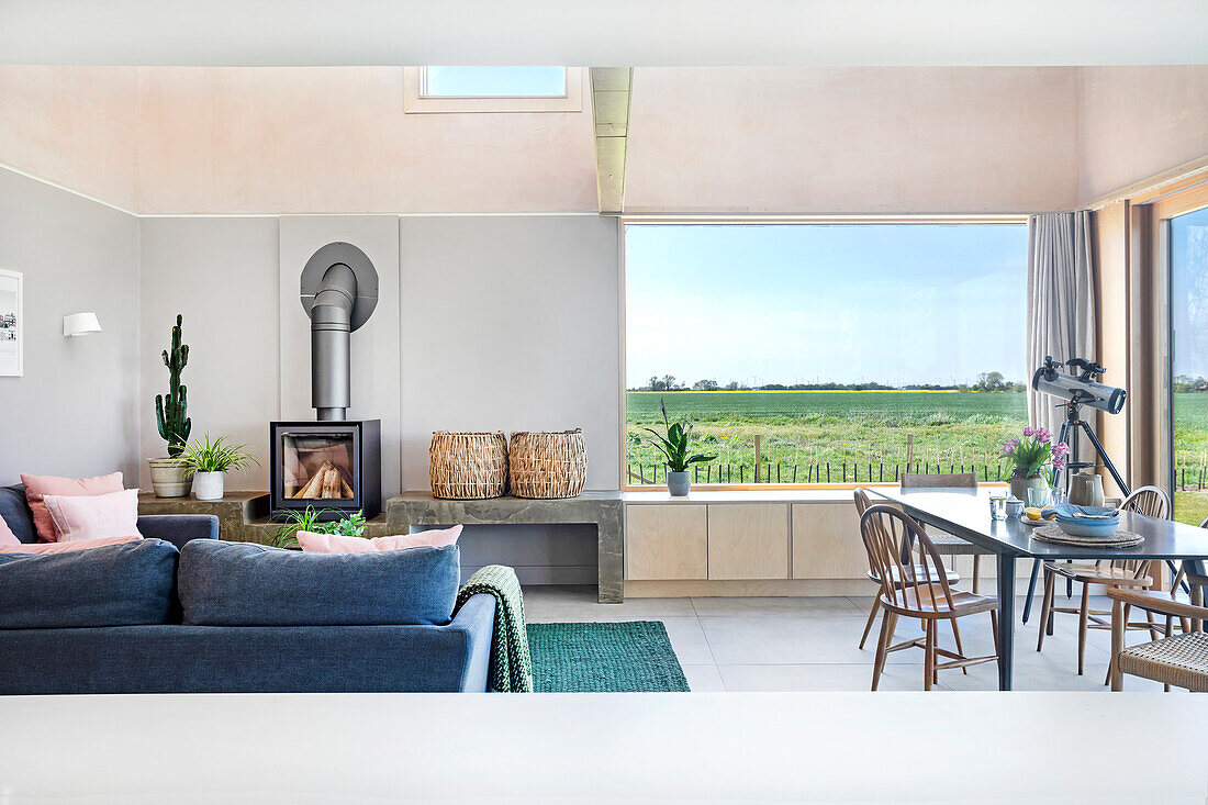 Open-plan living area with fireplace and panoramic windows, view of the yard