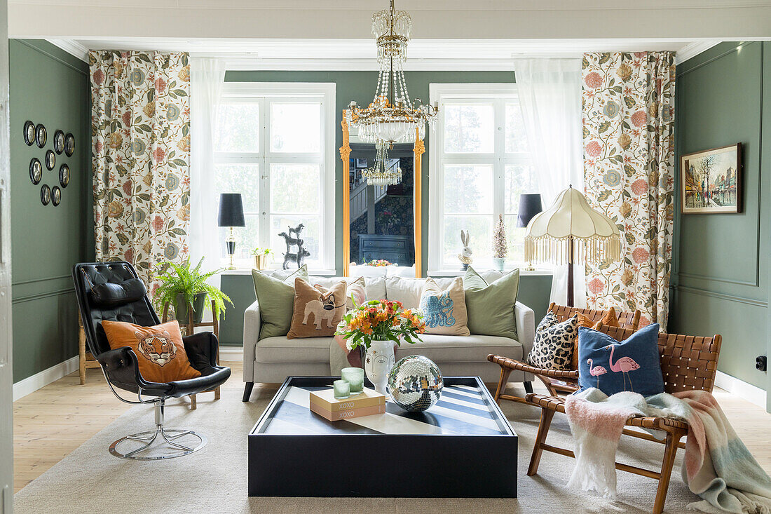 Living room with green walls, patterned curtains and decorative pillows