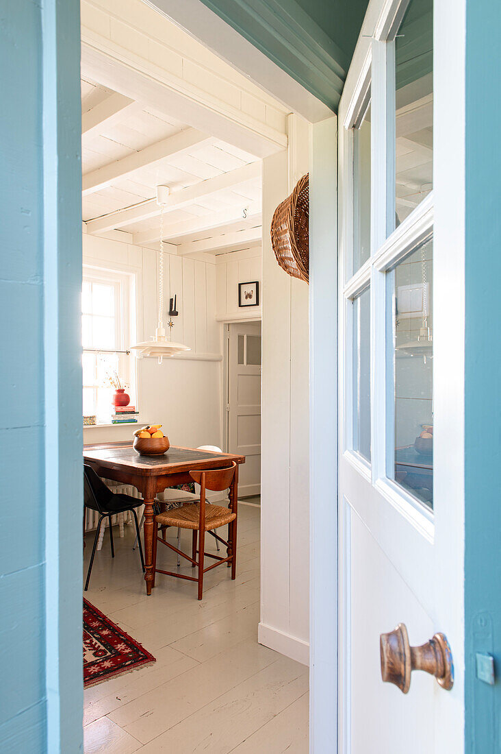 View through the door into the dining room with wooden table and assorted chairs