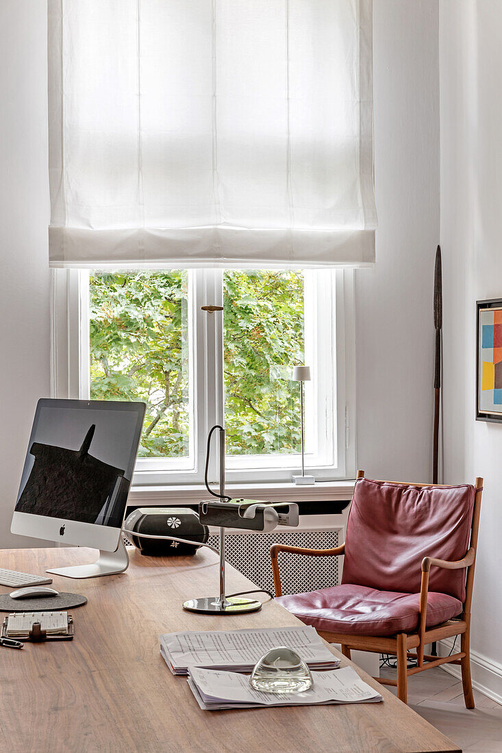 Home office with modern desk and leather armchair