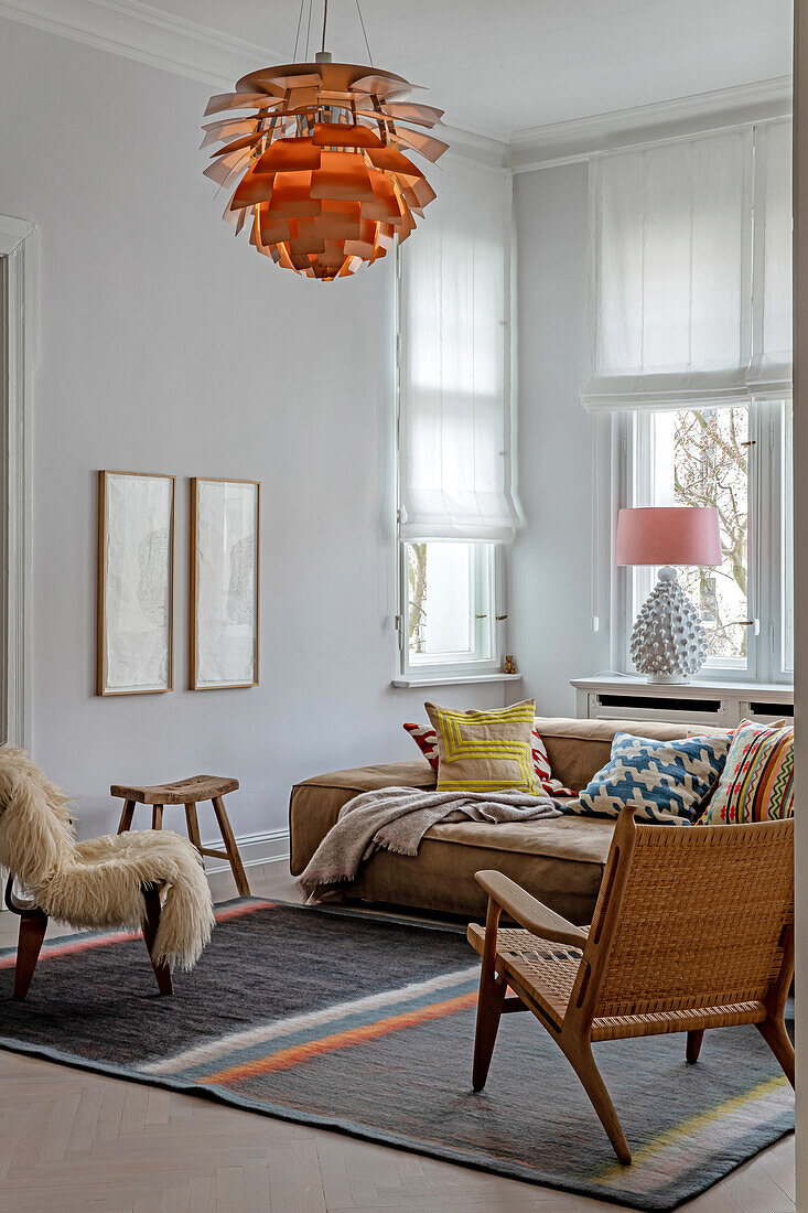 Living room with brown leather sofa, colorful throw pillows and eye-catching pendant light