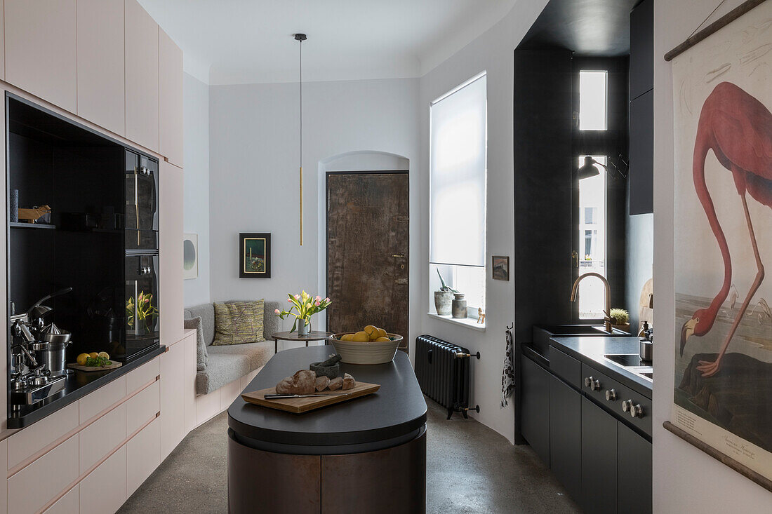 Modern kitchen interior with black kitchen island and pink cupboards