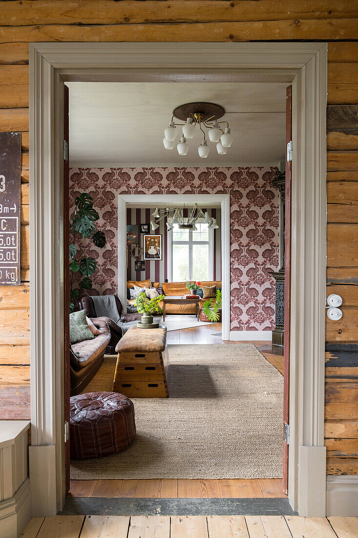 Eingangsbereich mit Blick auf Wohnzimmer mit gemusterten Tapeten und Vintage-Möbeln