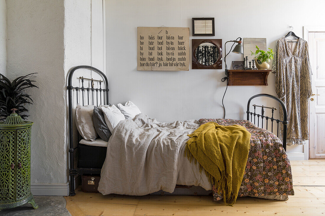 Doppelbett mit Metallrahmen und gemusterter Tagesdecke im Schlafzimmer