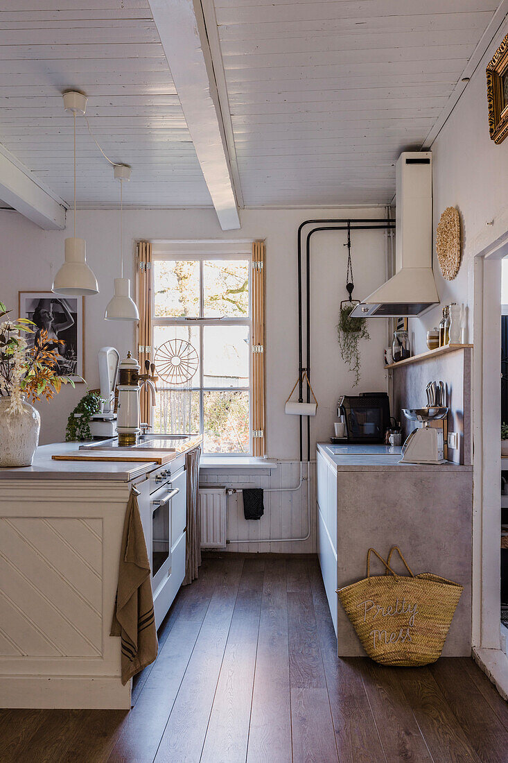 Kitchen with hanging lamps, wooden floor and extractor hood