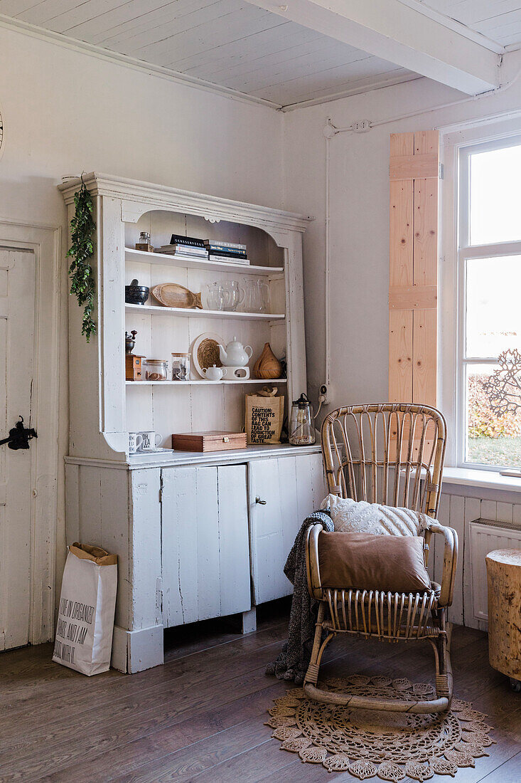 Vintage-Schrank und Schaukelstuhl aus Rattan im Landhausstil