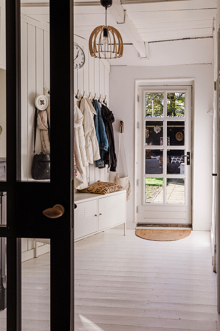 Inviting hallway with white wood panelling and patio door