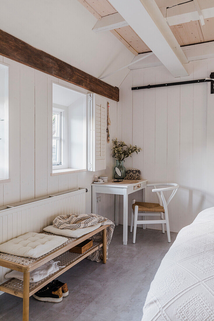 Bright bedroom with wooden beams and white table