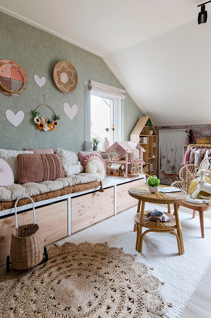 Children's room in the attic with playhouse, rattan furniture and storage space