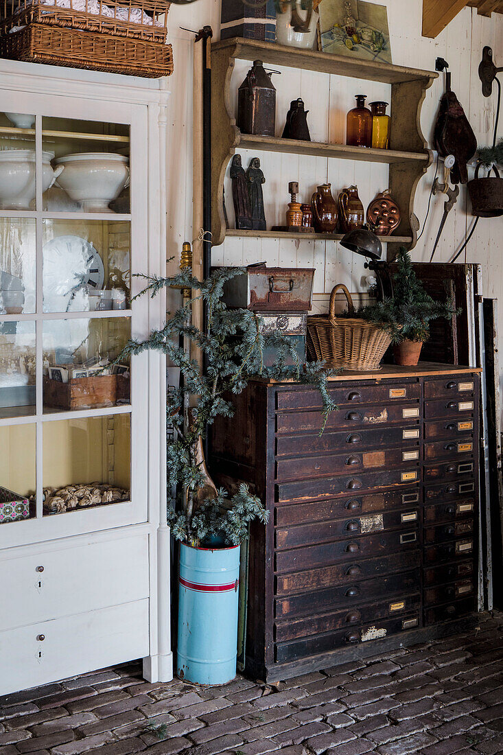 Dunkler Vintage-Schrank mit Schubladen und weiße Vitrine im Landhausstil