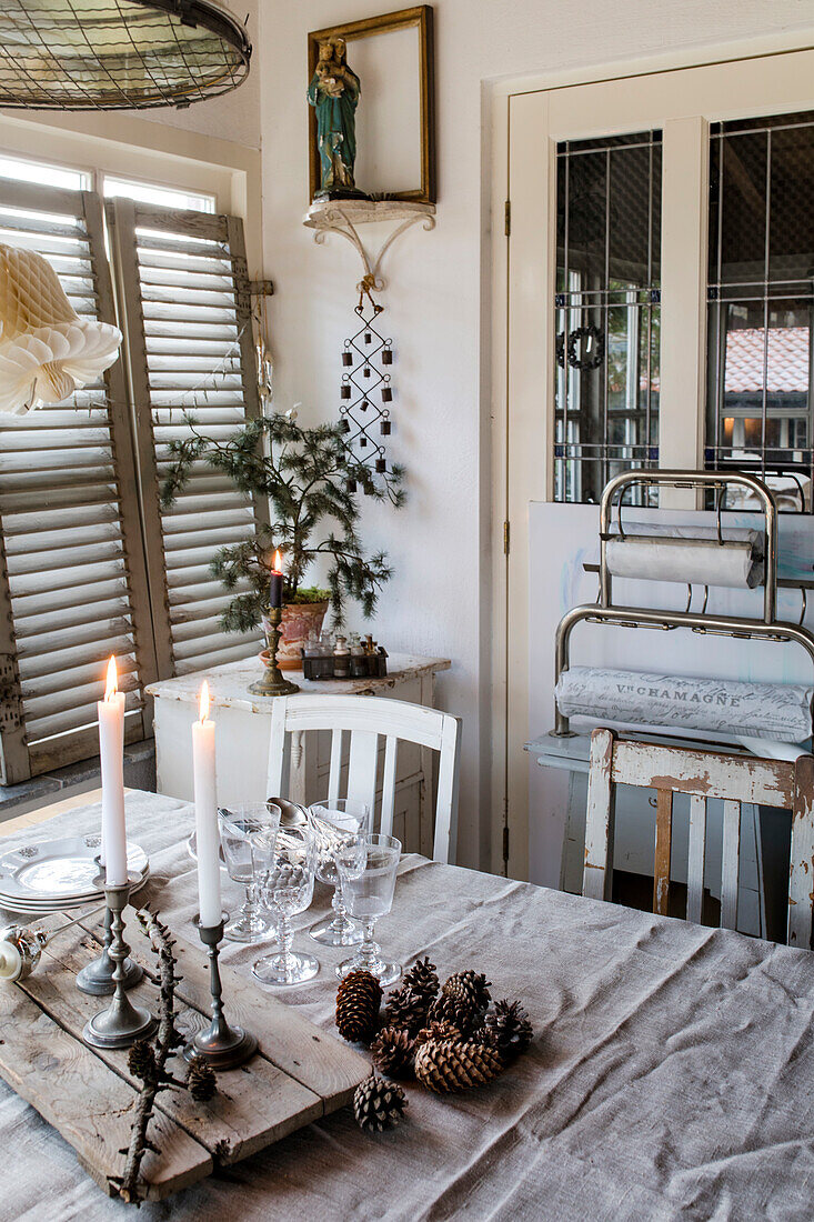 Dining table with candles and pine cones in a vintage look