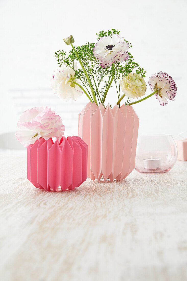 Folded paper flower vases with spring flowers