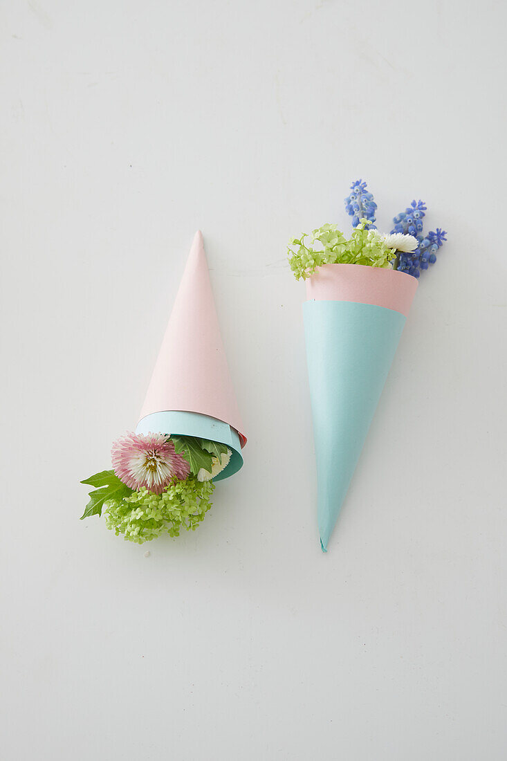 Paper cones with spring flowers on a white background