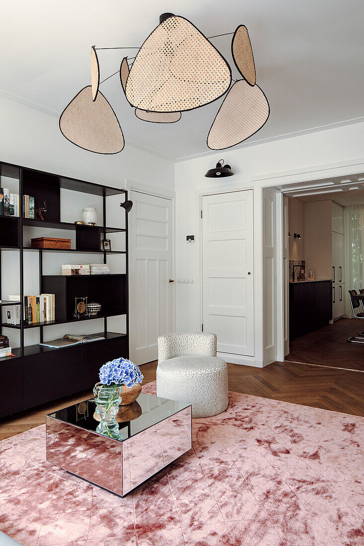 Modern living room with armchair, mirror coffee table and wire pendant lights