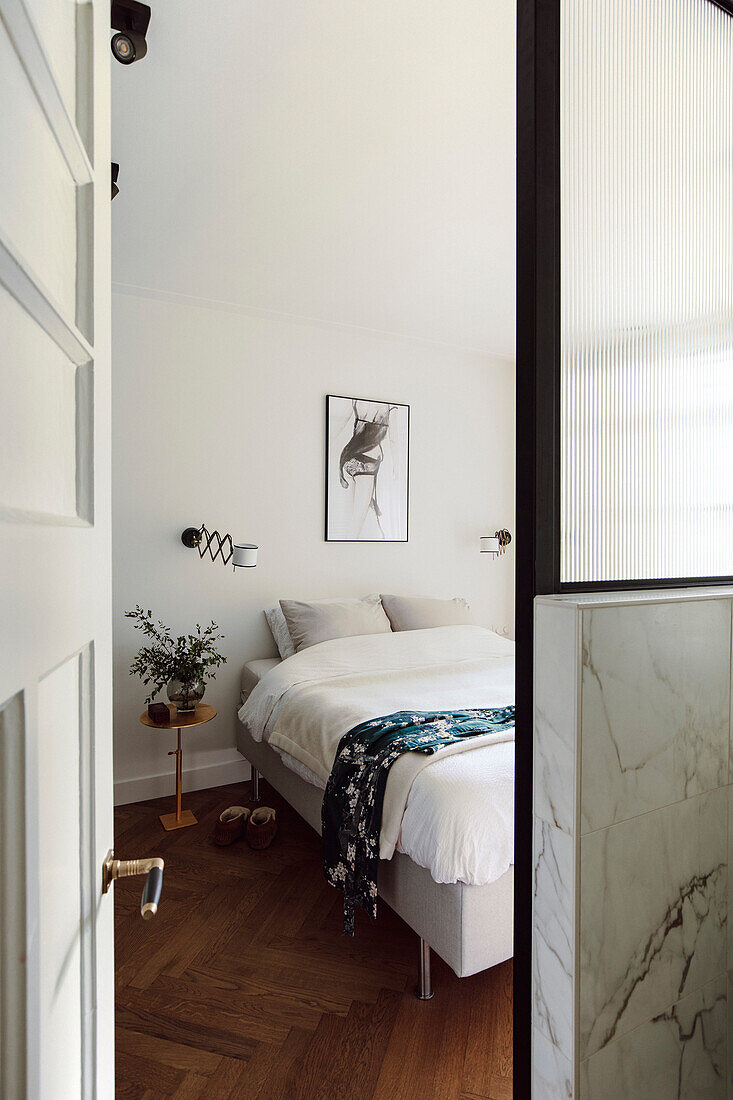 Simple bedroom with white bed linen and glass wall