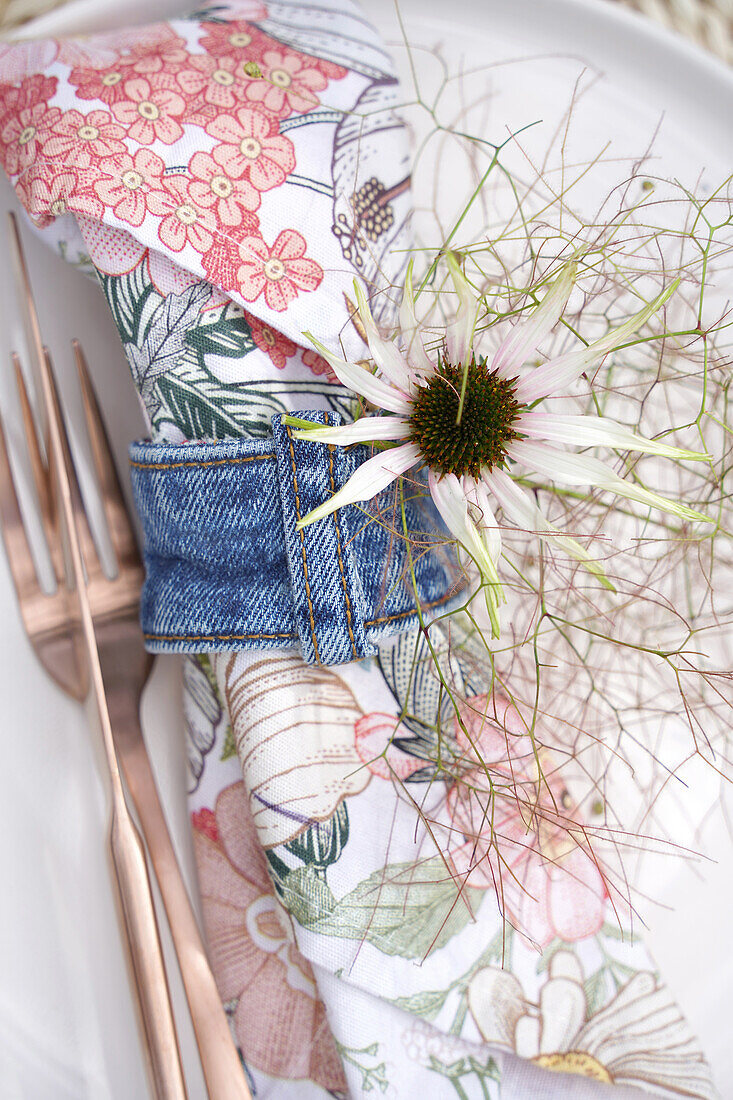 Cutlery, floral napkin and sun hat (echinacea) in denim napkin ring