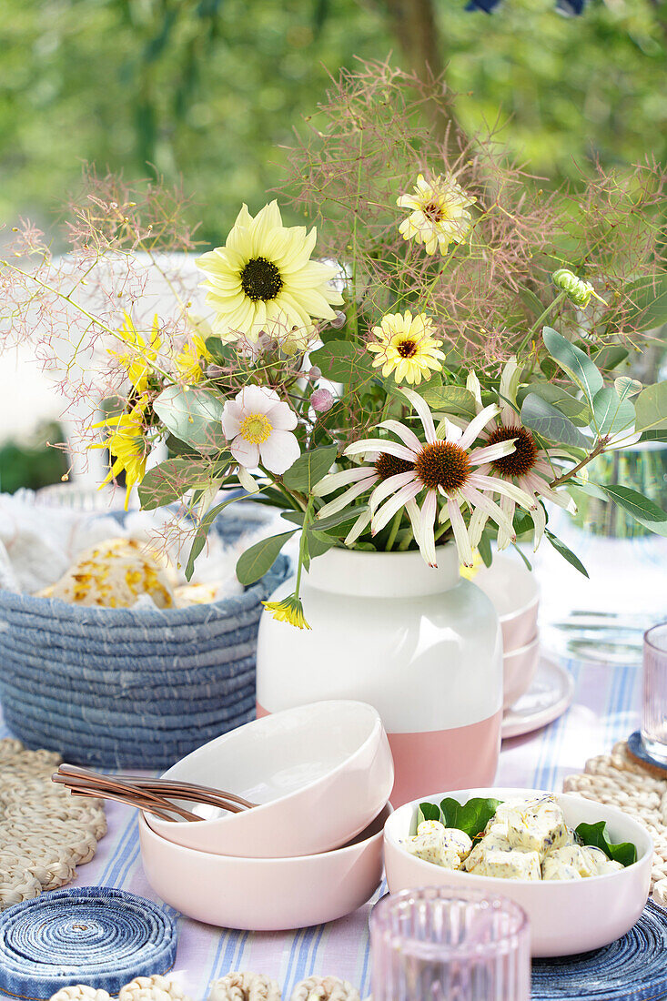 Sommerlicher Blumenstrauß auf gedecktem Gartentisch