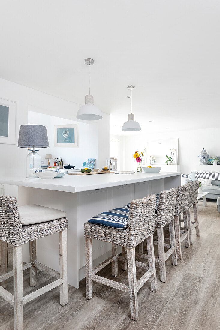 Bright kitchen with white kitchen island, bar stools and pendant lights