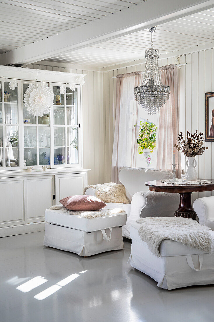 Helles Wohnzimmer mit Kristalllüster und weißen Möbeln