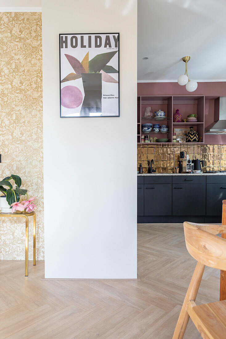 Open-plan kitchen with golden tiled backsplash and black cupboards