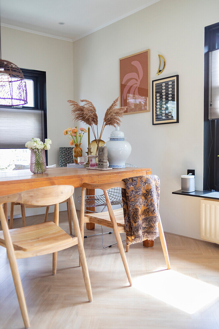 Bright dining room with wooden table, chairs and pampas grass decoration