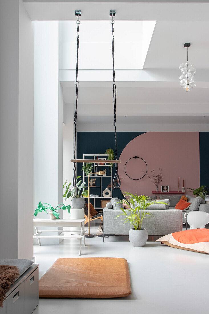 Spacious living area with gymnastic rings and arched wall painting