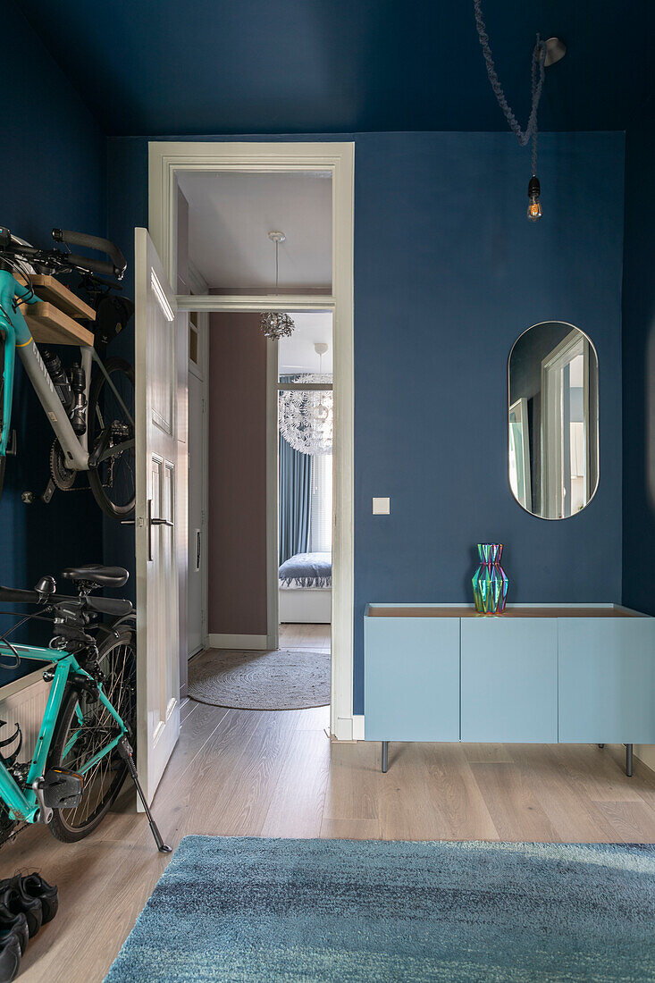 Modern hallway in blue with bicycles and sideboard