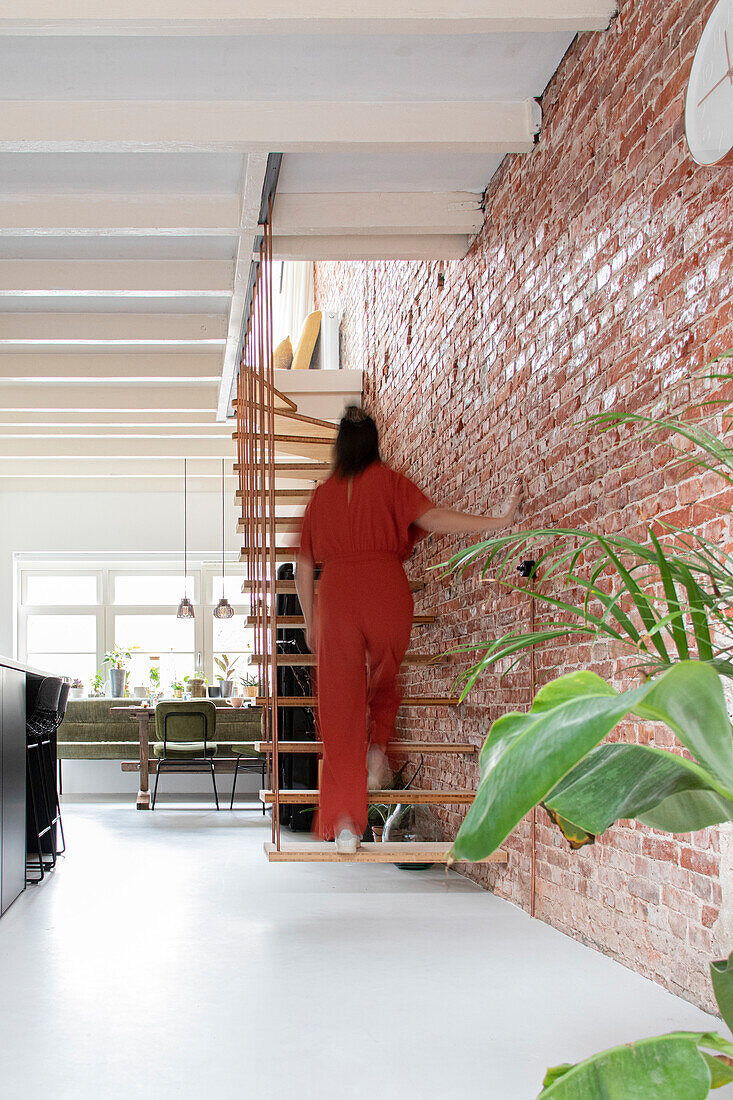 Hängende Treppe und Backsteinwand in modernem Wohnraum