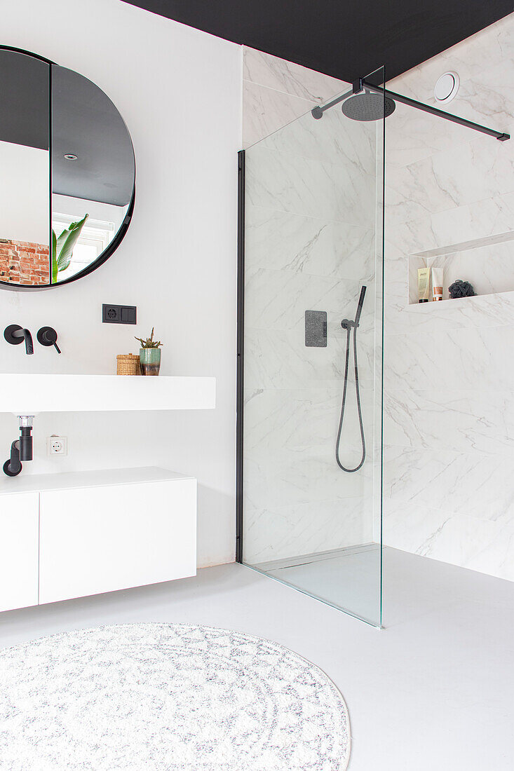 Modern bathroom with walk-in shower and round mirror